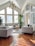 A modern living room with large windows and stylish furniture, showcasing a bright and inviting space.