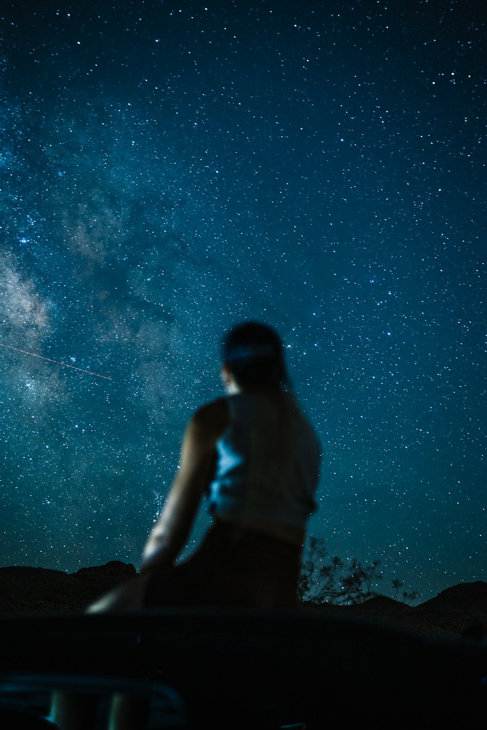 une personne debout devant un ciel étoilé