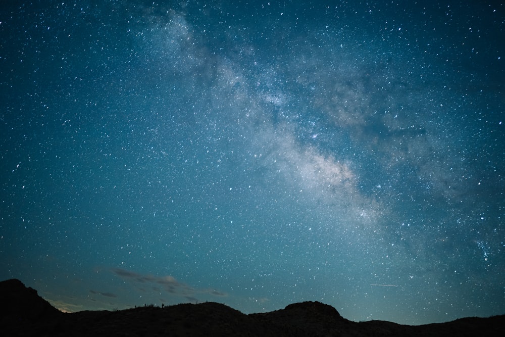 a starry night sky over a mountain range