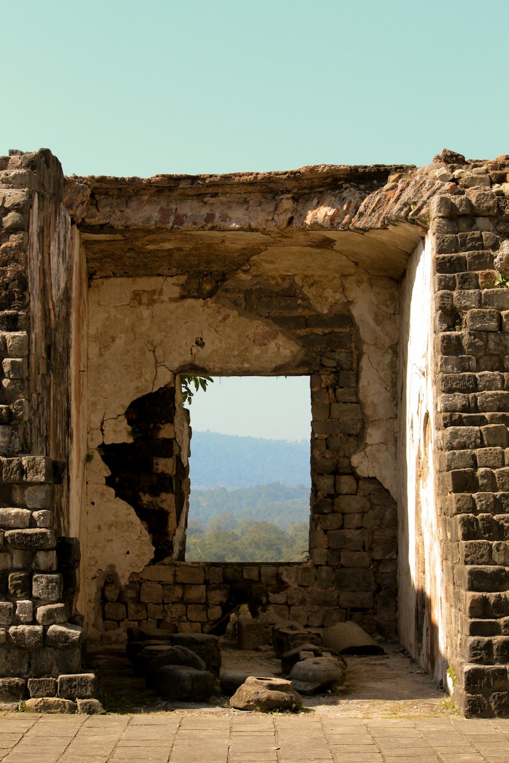 a stone building with a view of a mountain and a valley