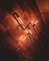 An industrial lamp crafted from repurposed pipes casting warm light.