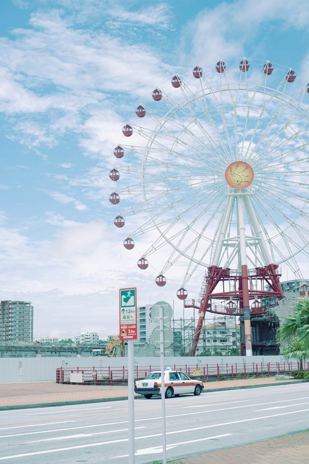 a ferris wheel with a car driving by