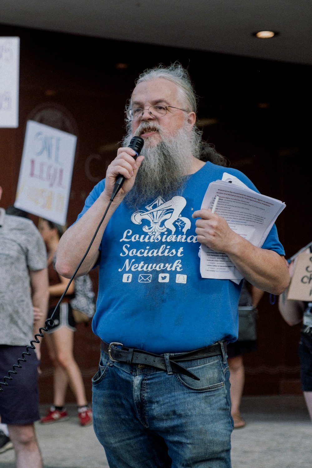 a person holding a microphone and a paper