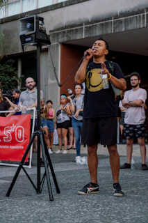 A speaker passionately addressing the audience with a warm, inviting smile.