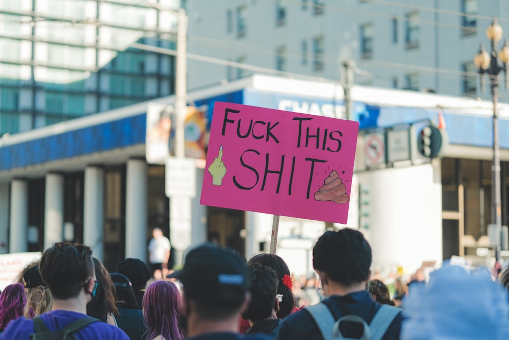 a group of people walking down a street holding a sign