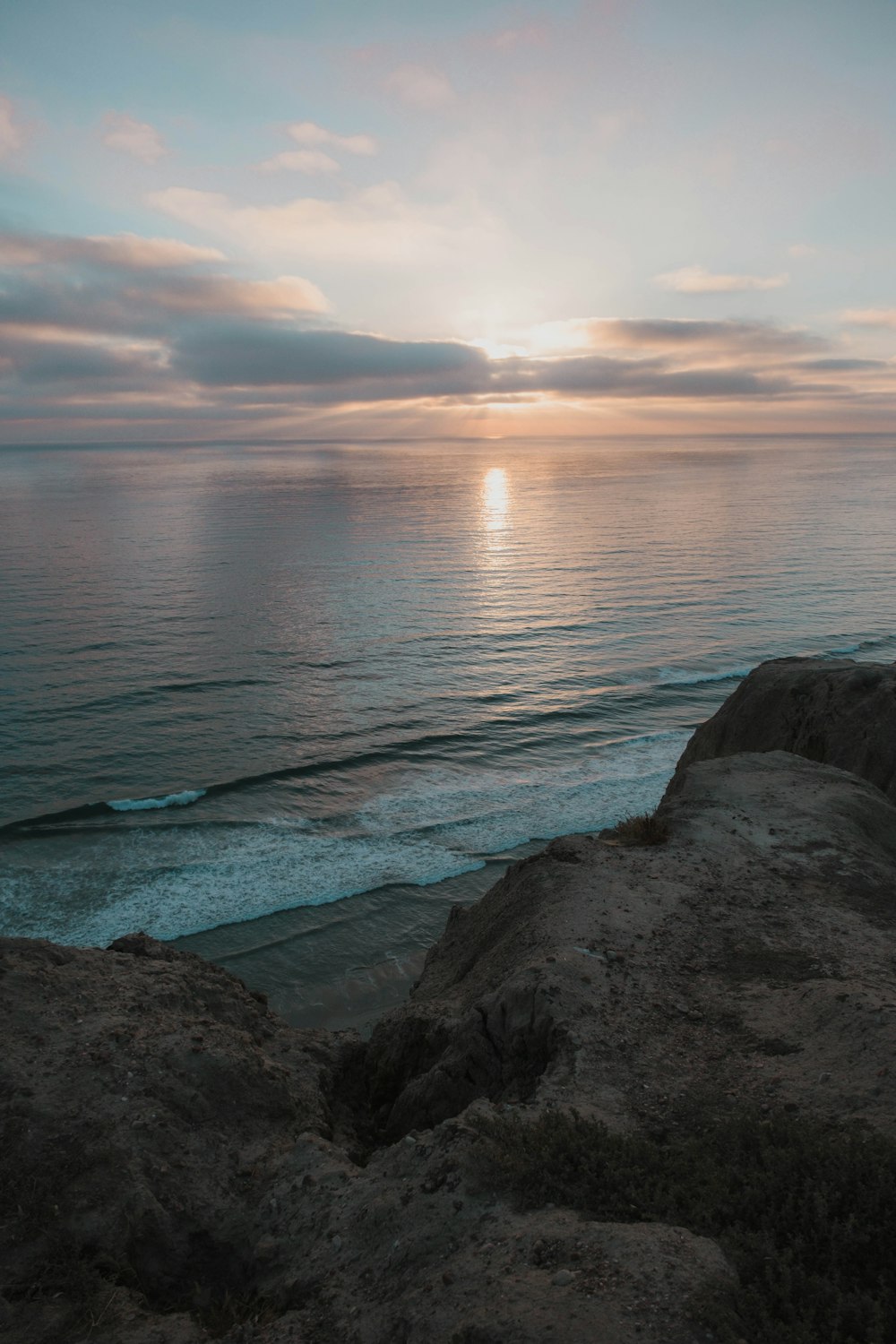 a rocky beach with a body of water in the background