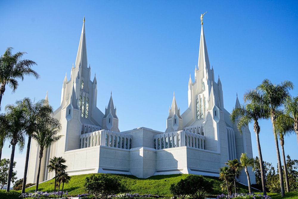 a white building with towers and palm trees with Brigham City Utah Temple in the background