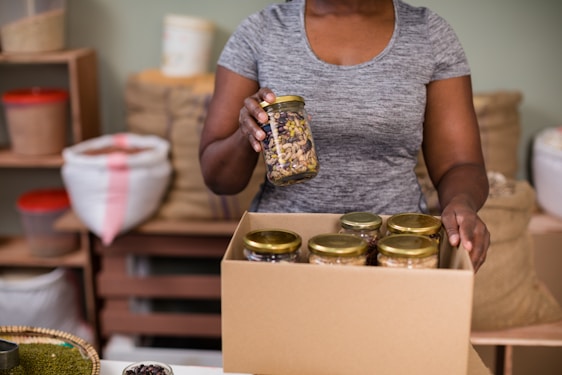 Photo of Carlos Fernandes packing bottles of olive oil and jars of honey carefully for home delivery.
