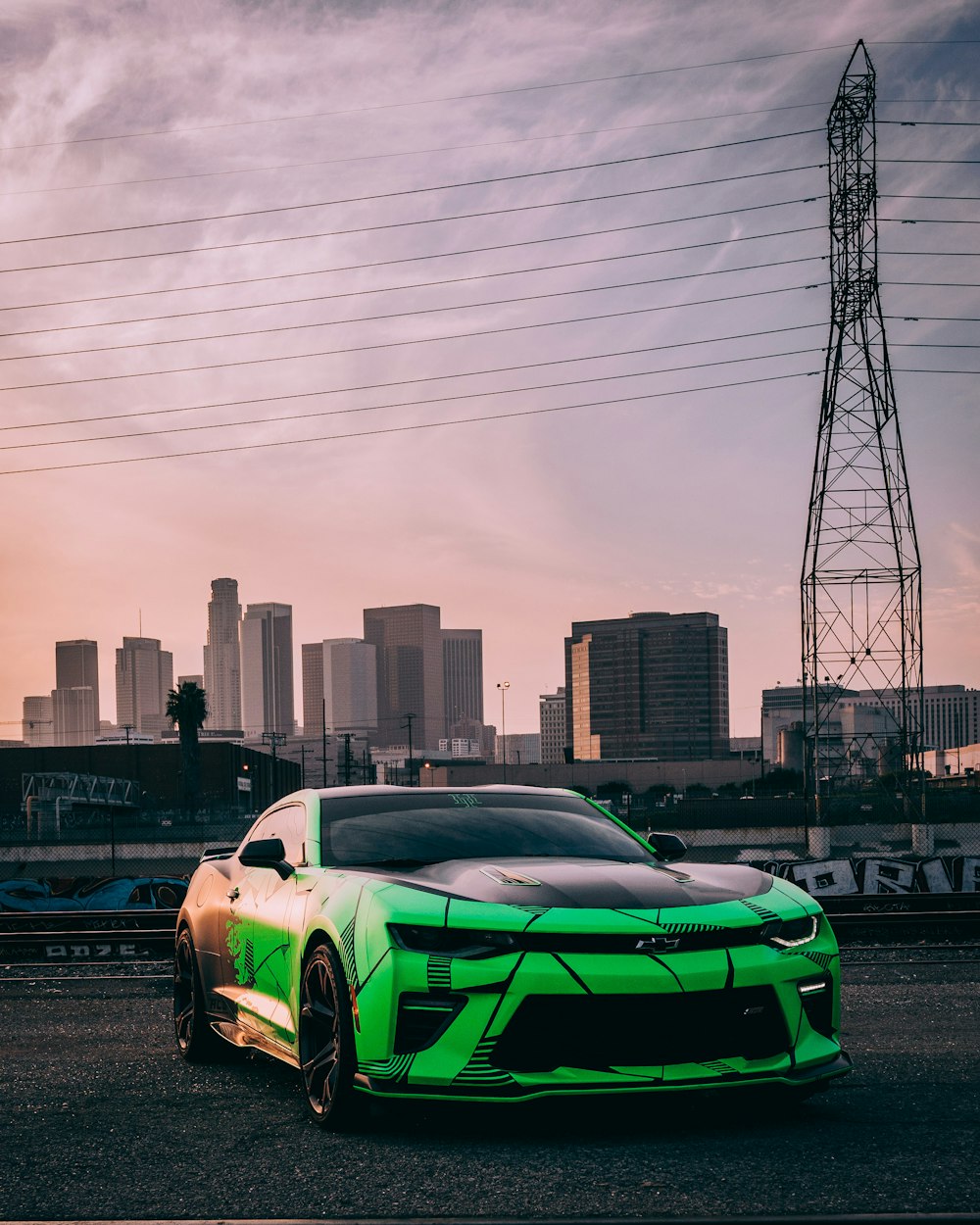 a sports car parked in front of a city skyline