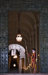 a person in a robe standing in a doorway with a light from the ceiling