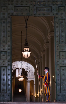 a person in a robe standing in a doorway with a light from the ceiling