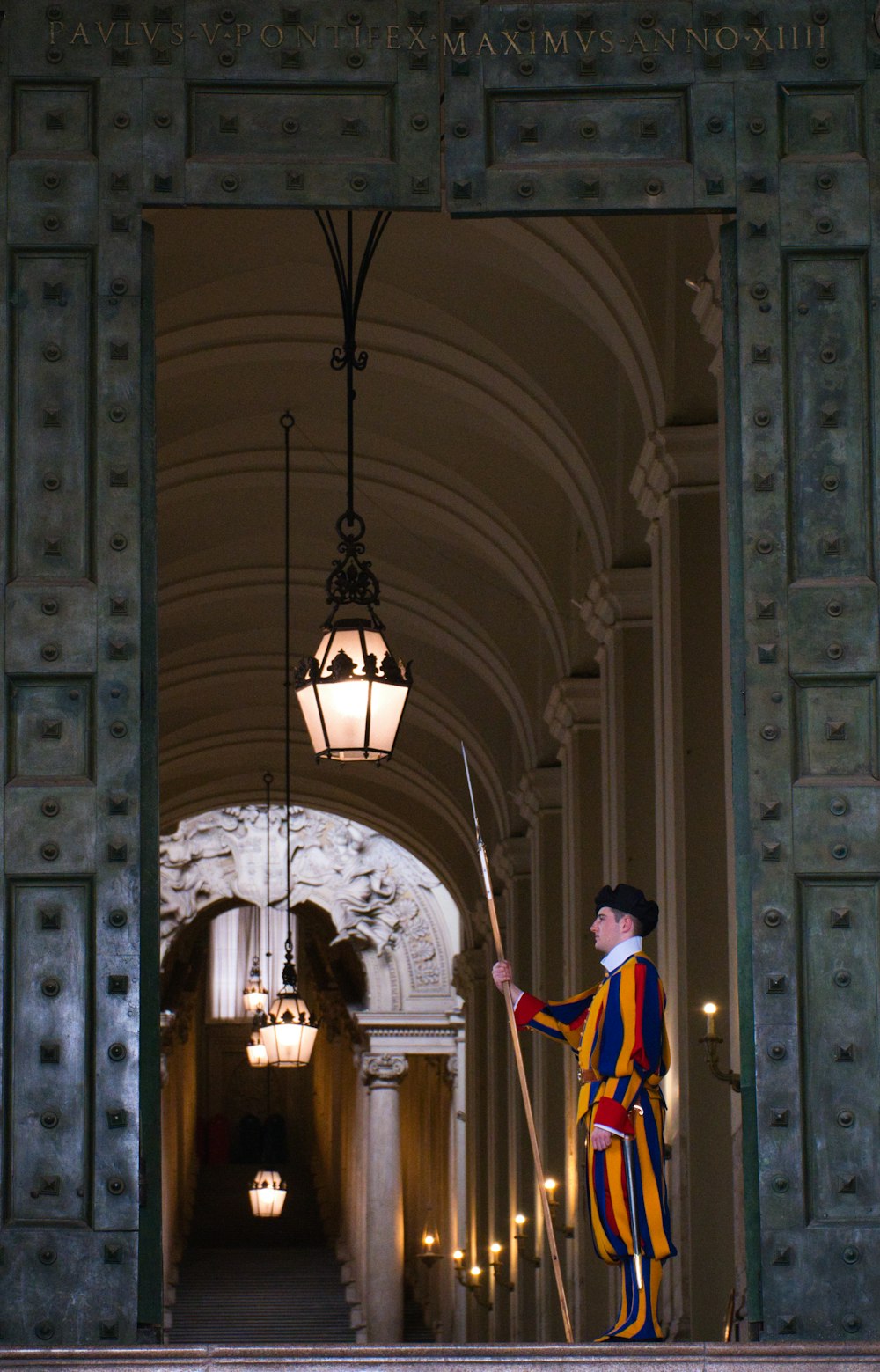 a person in a robe standing in a doorway with a light from the ceiling