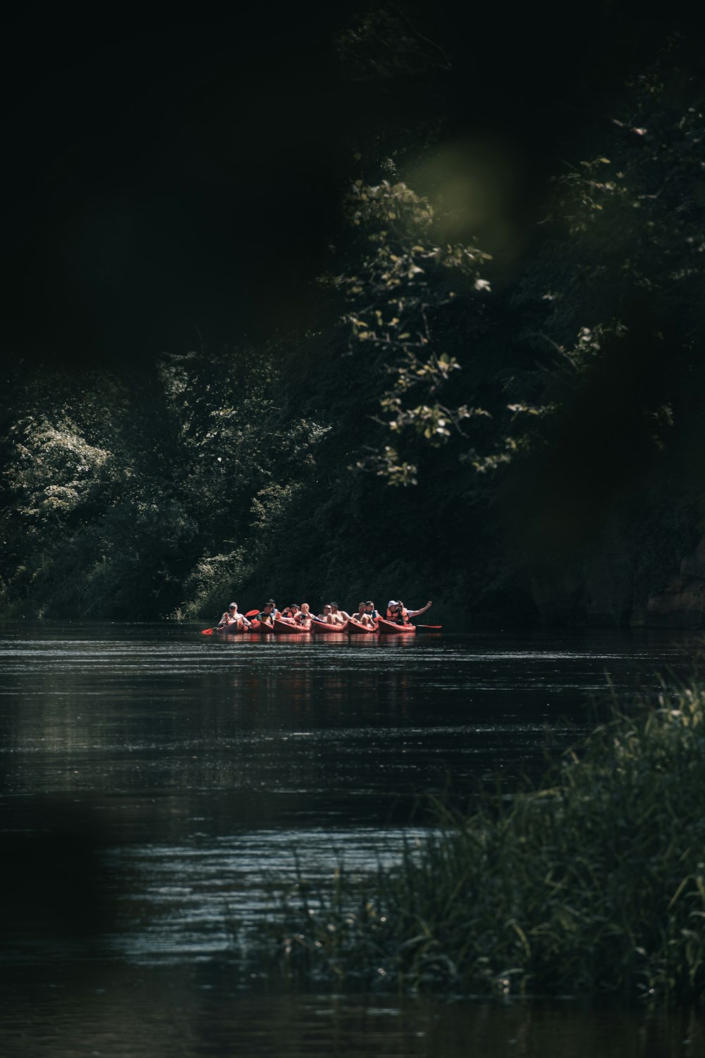 a group of people in a row boat on a lake at night