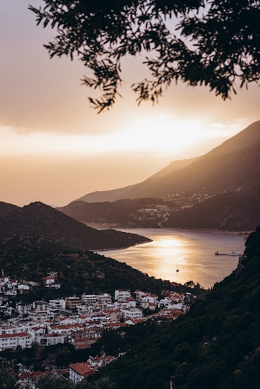 A serene view of the Karadeniz coastline at sunset, with gentle waves and lush green hills.