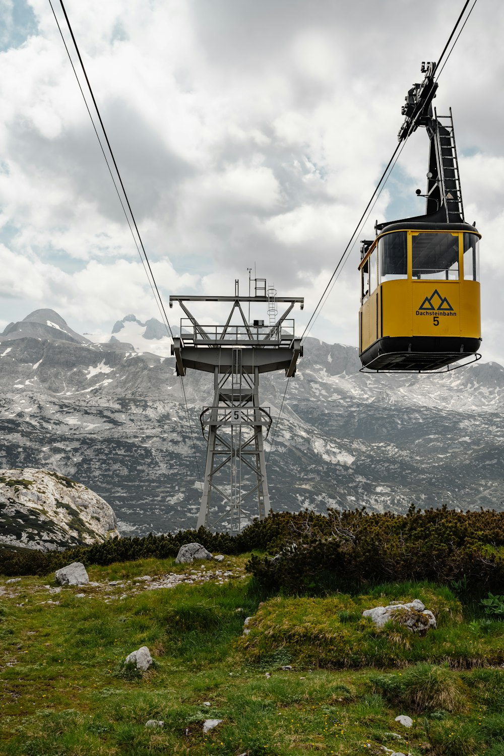 a yellow cable car on a mountain