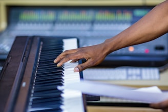 Close-up of Keane Austin’s hands crafting melodies on a keyboard, blending human touch with AI.