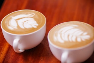 Cozy coffee shop interior with wooden tables and cups of latte.