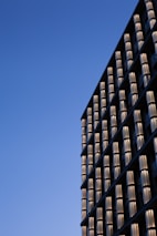 Modern glass curtain wall reflecting blue sky on a commercial building.