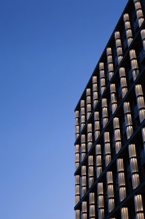 Exterior view of a modern glass facade sparkling under a clear blue sky