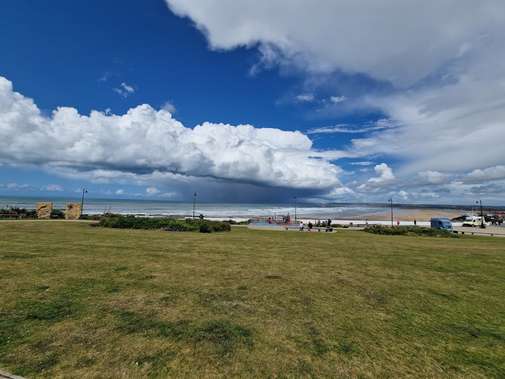 a large field with buildings and a body of water in the background