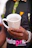 Close-up of a ceramic mug featuring Cuban artwork, held by hands with a Cuban flag bracelet.