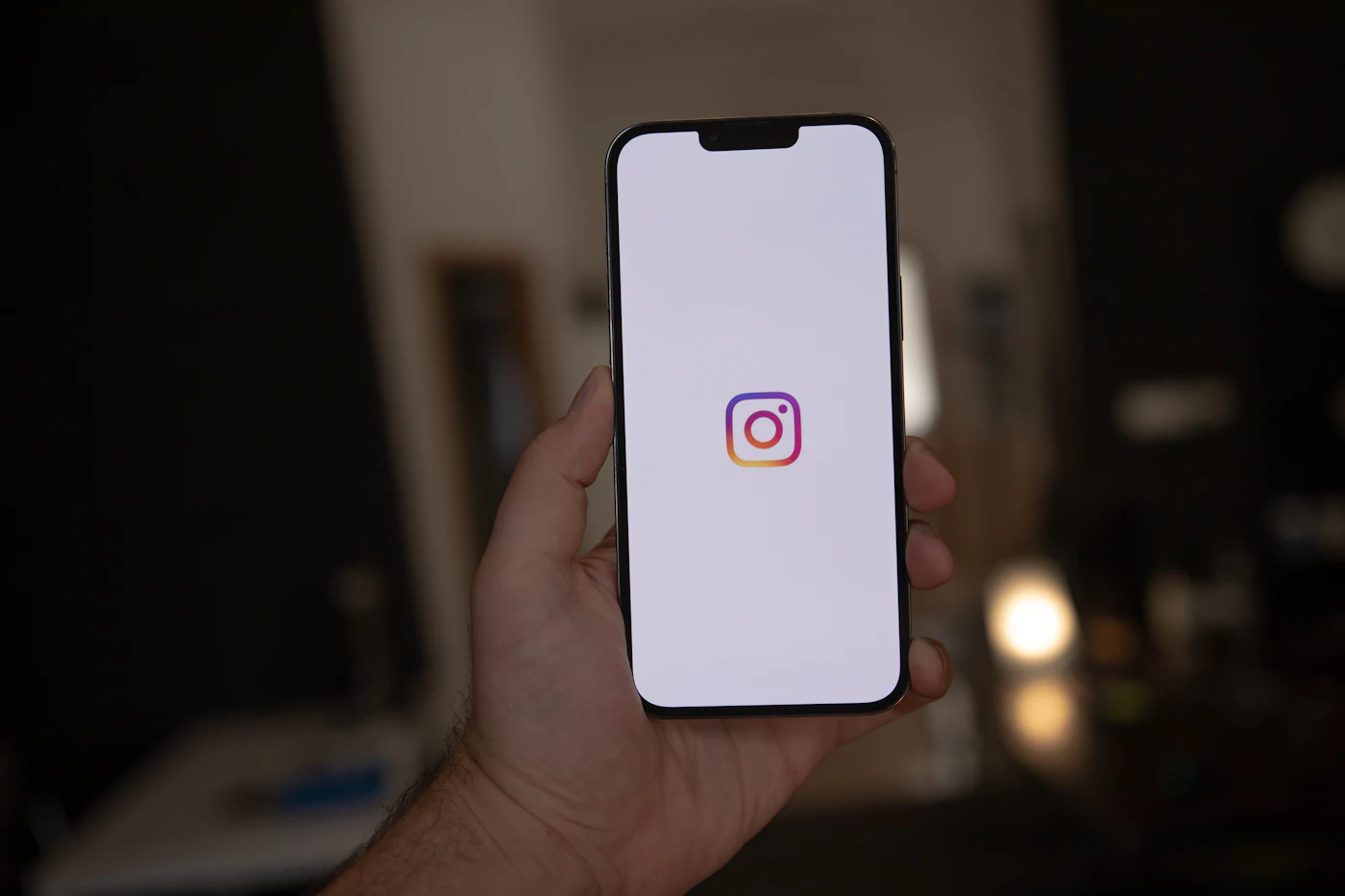 Mano sujetando un móvil con Instagram abierto, de noche