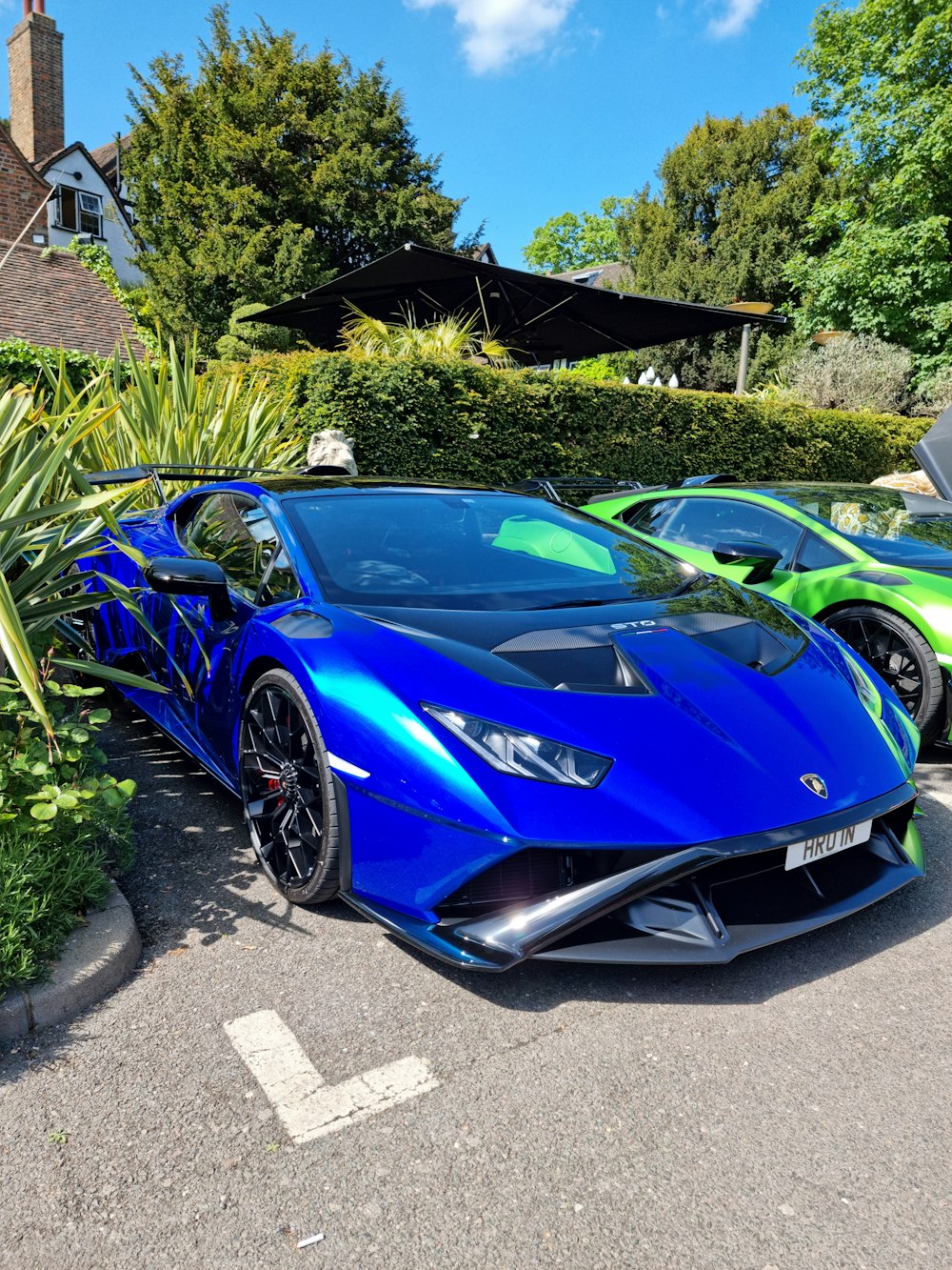 a blue sports car parked next to a green car