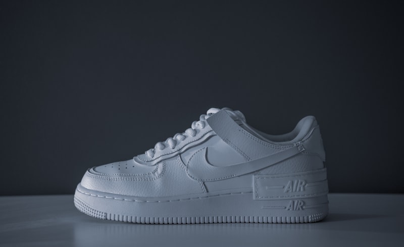 Para białych sneakersów na neutralnym tle