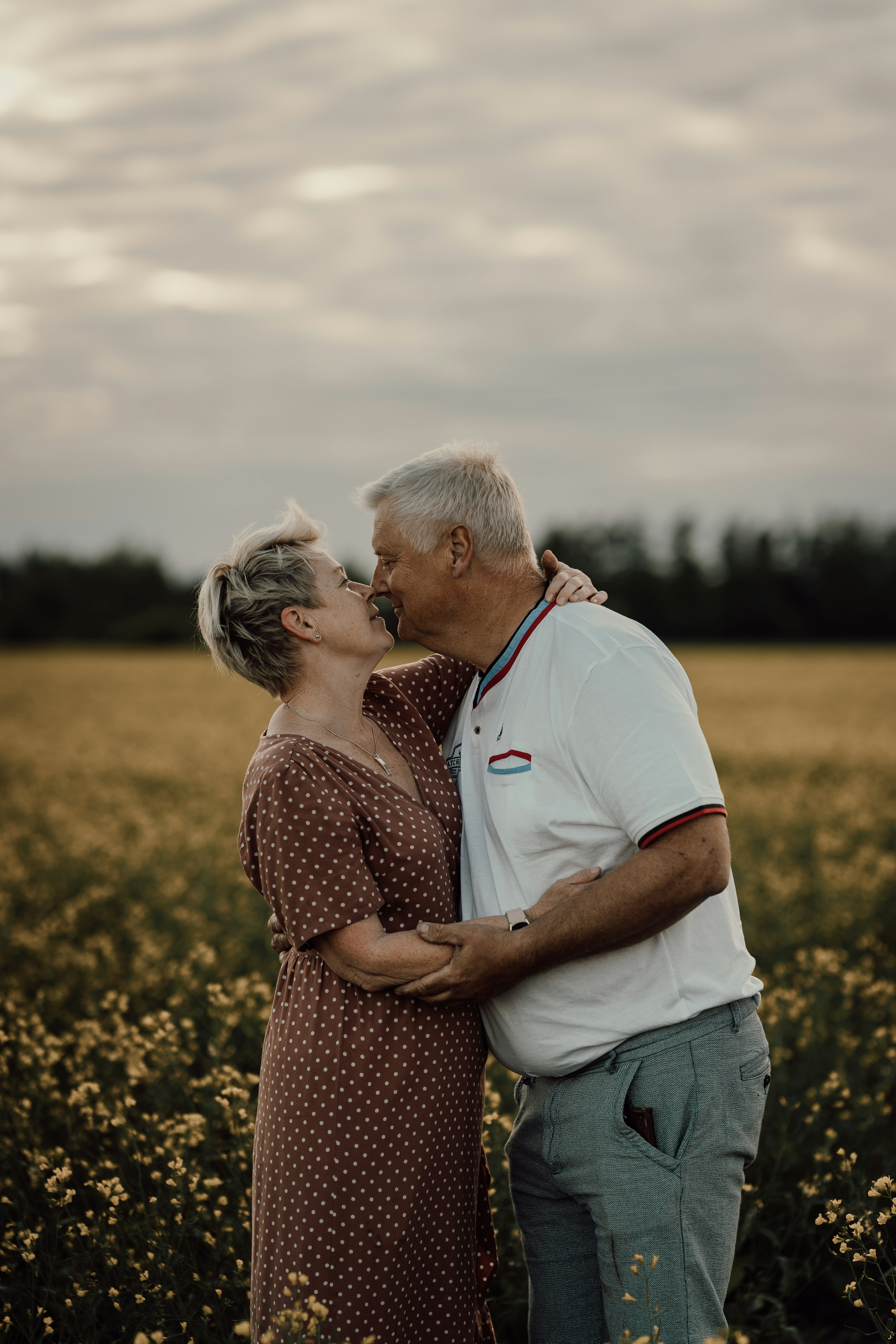 A man and woman kissing in a field of flowers photo – Free Grey Image ...