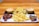 A wooden table holds a serving platter featuring crispy fries in the center, flanked by two small meat pies. Adjacent to the fries are portions of glazed chicken wings, sprinkled with herbs and sesame seeds. The food items rest on rectangular serving trays.
