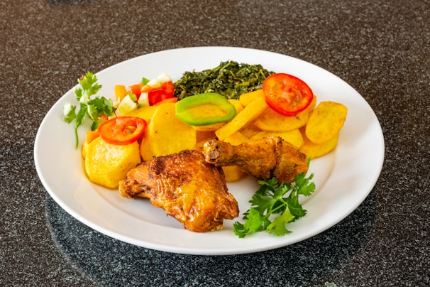 Assorted chicken cuts including thighs, livers, and hearts on a clean white platter.