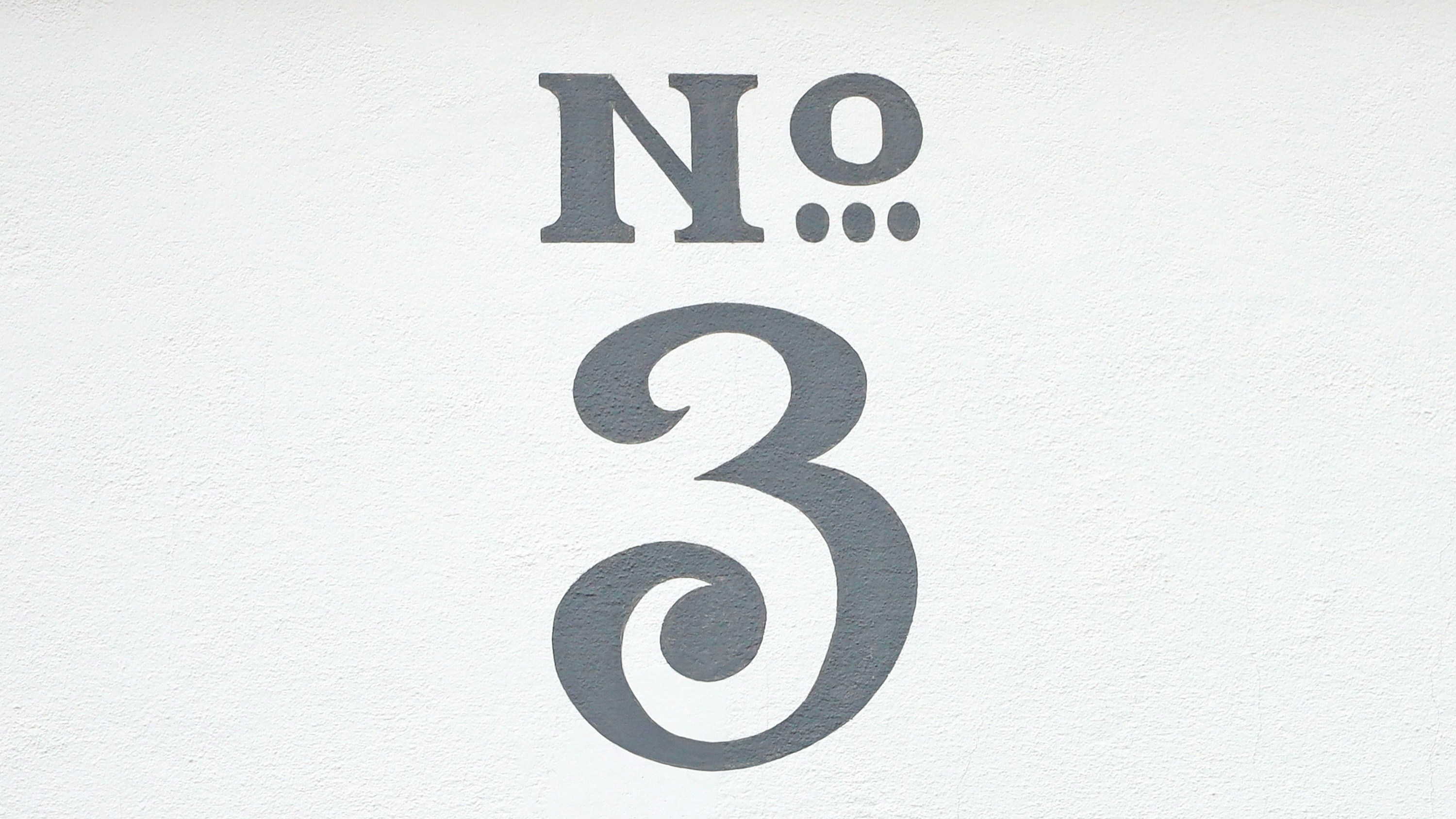 No 3 painting in classic style on a house wall.