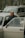 A smiling elderly woman being assisted into a vehicle by a friendly driver.