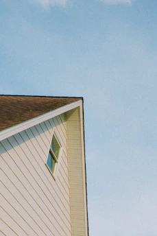 A house featuring fresh, crisp vinyl siding under a clear blue sky.