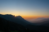 A scenic view of mountains visible from a hotel room window at sunrise.