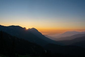 A happy traveler looking at a scenic mountain view during sunrise