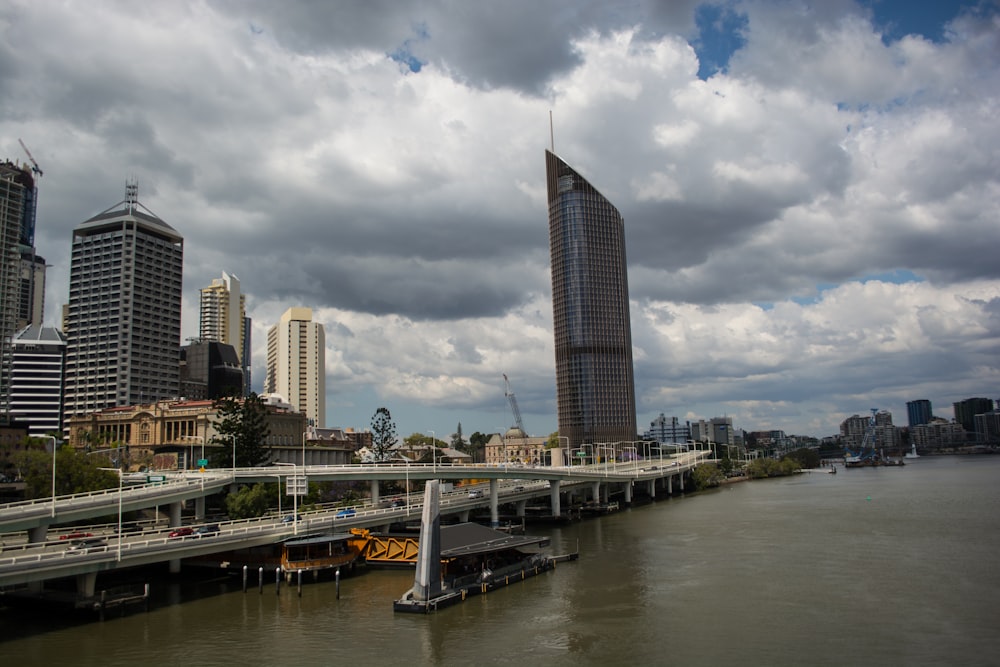 a bridge over a river with a city in the background