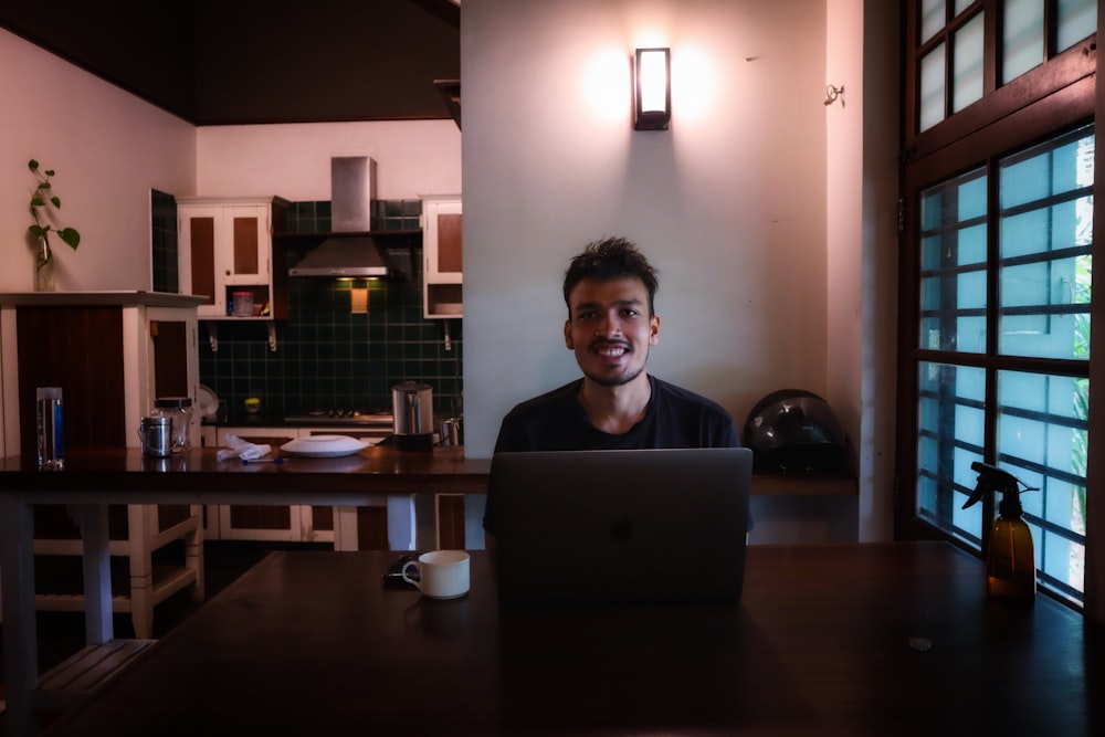 a man sitting at a table with a laptop