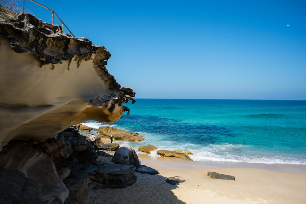 a rocky beach with a large body of water in the background