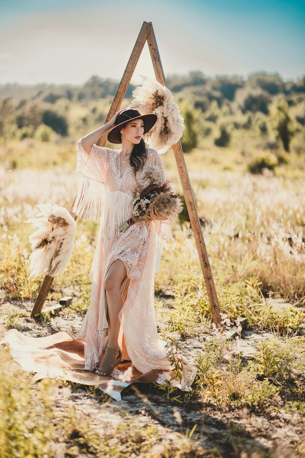 Una persona con un vestido blanco sosteniendo un palo en un campo