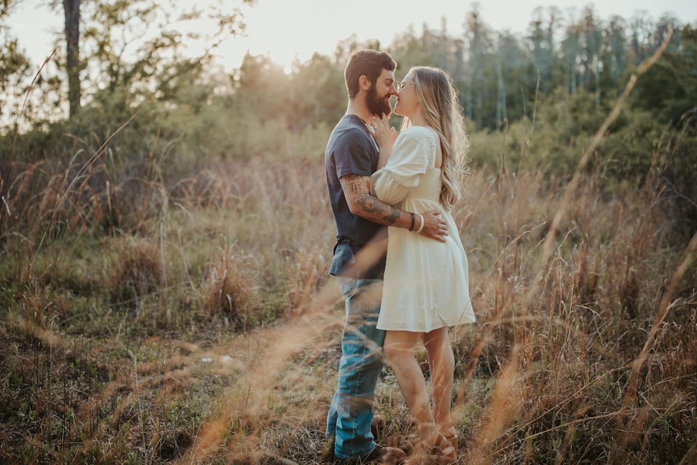 a man and woman kissing in a field of tall grass