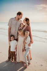 a family posing on a beach