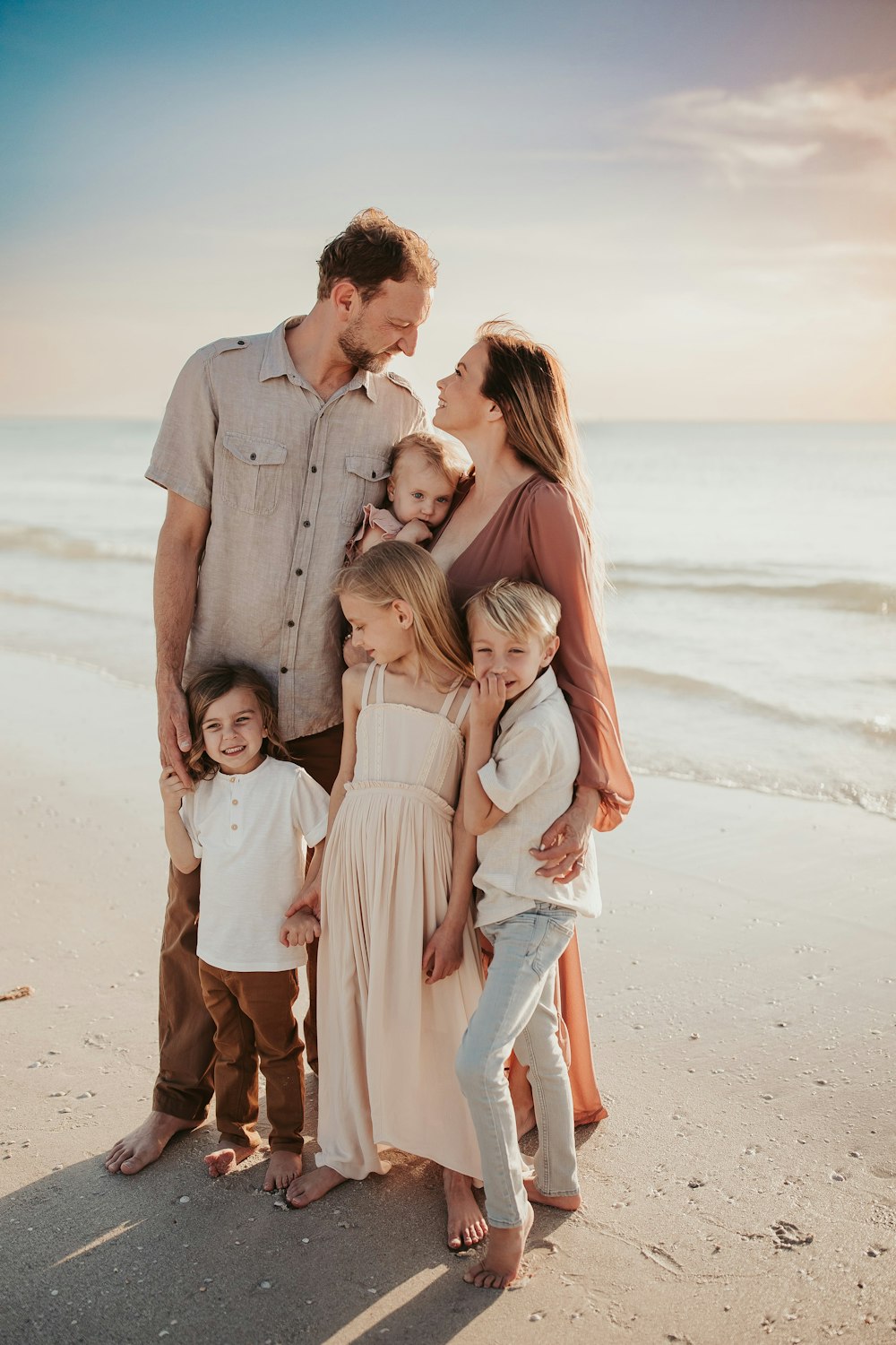a family posing on a beach