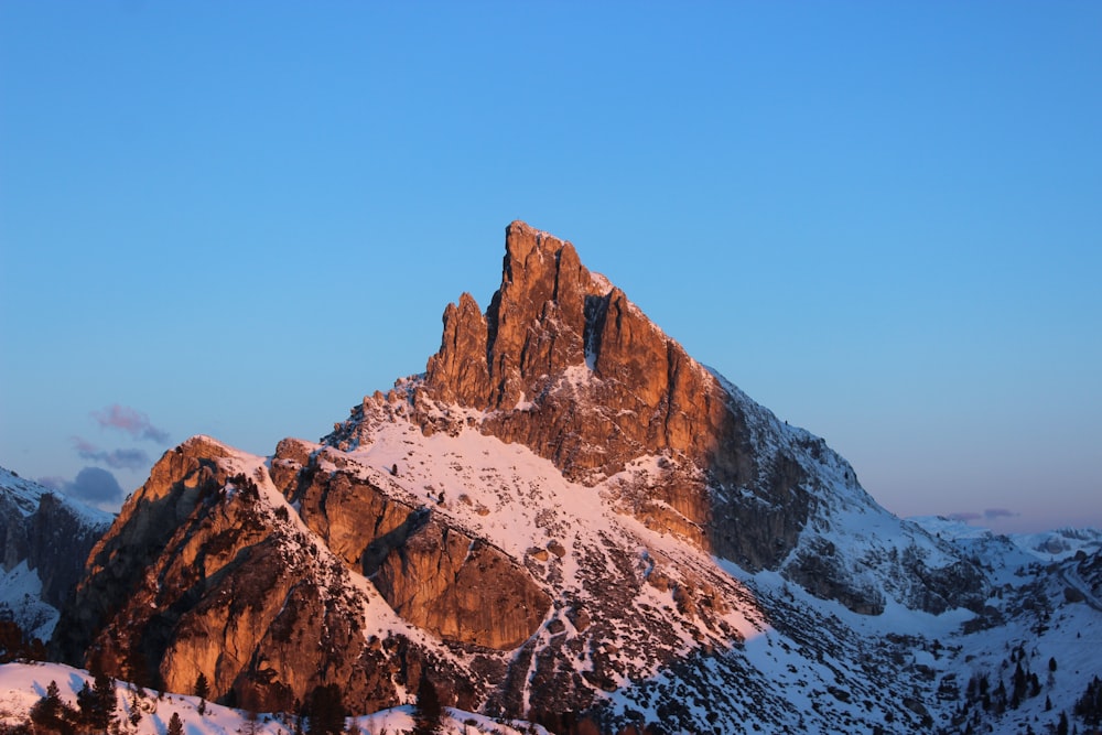 a snowy mountain with a blue sky