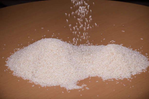 A rustic sack of raw Sona Masoori rice grains spilling onto a wooden surface.