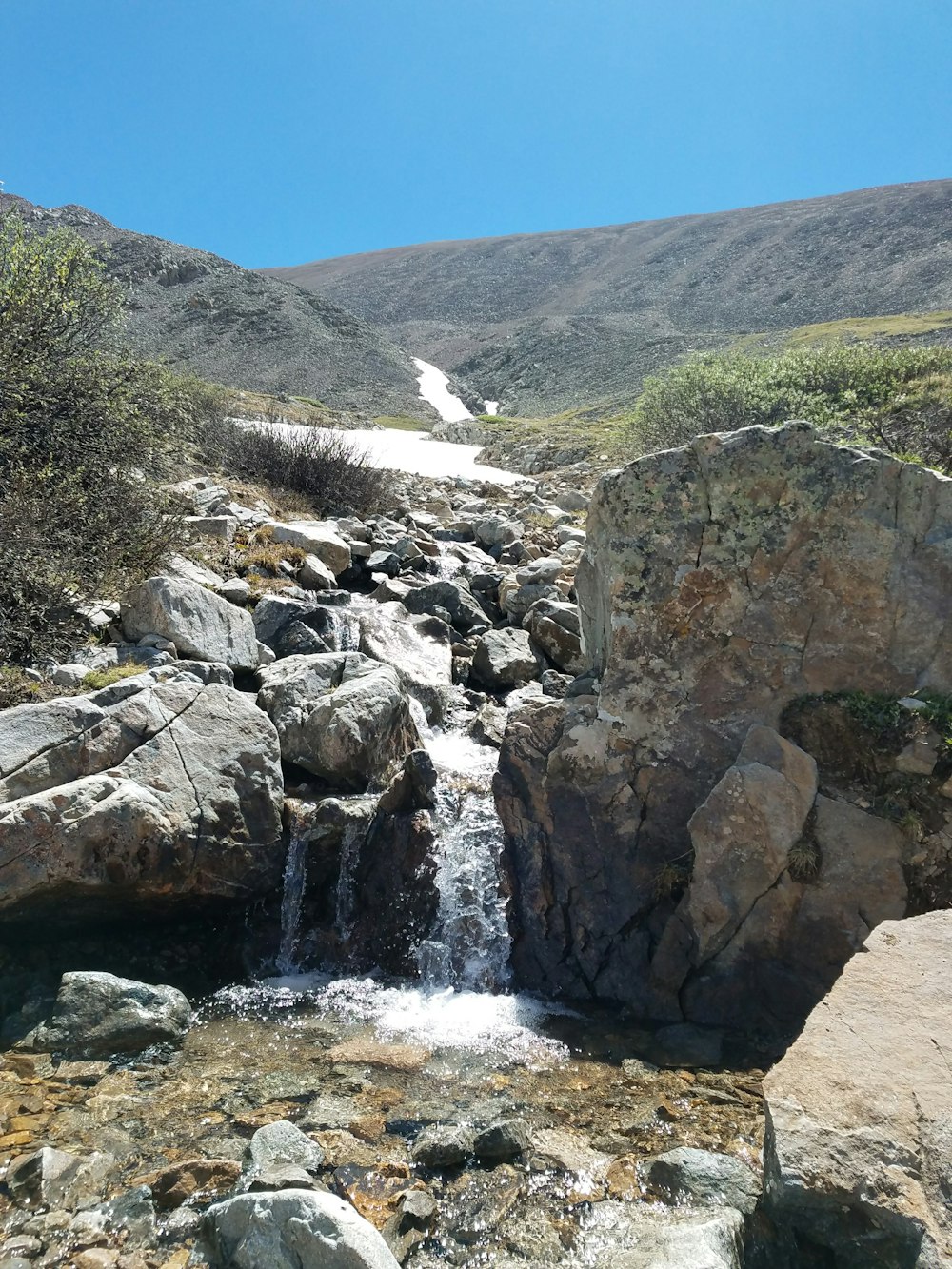 a rocky river flowing through a valley