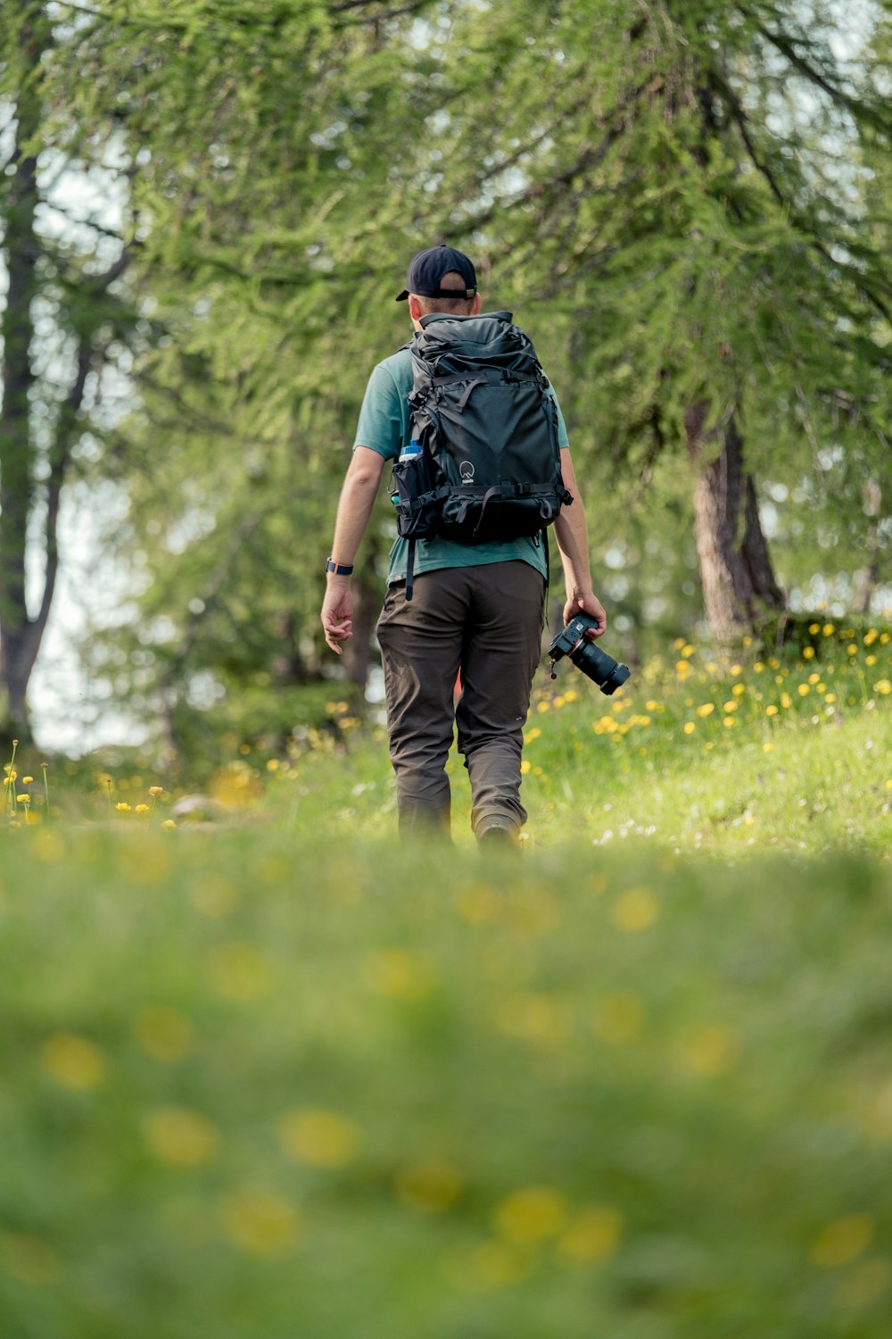 a man with a camera walking through a field of flowers
