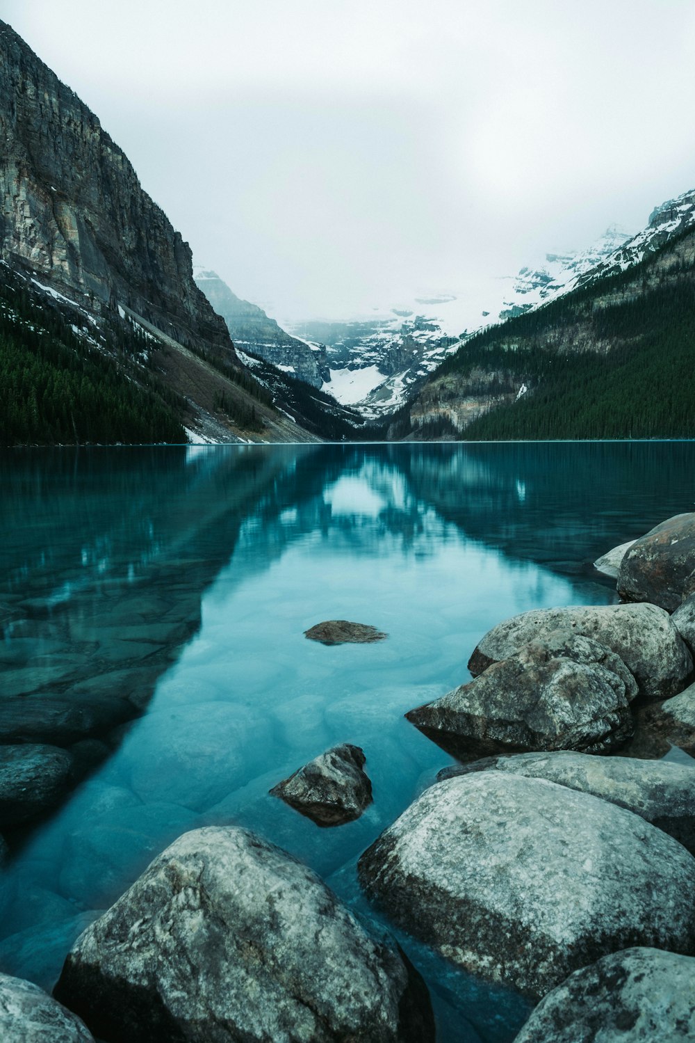 a body of water with rocks and mountains in the background