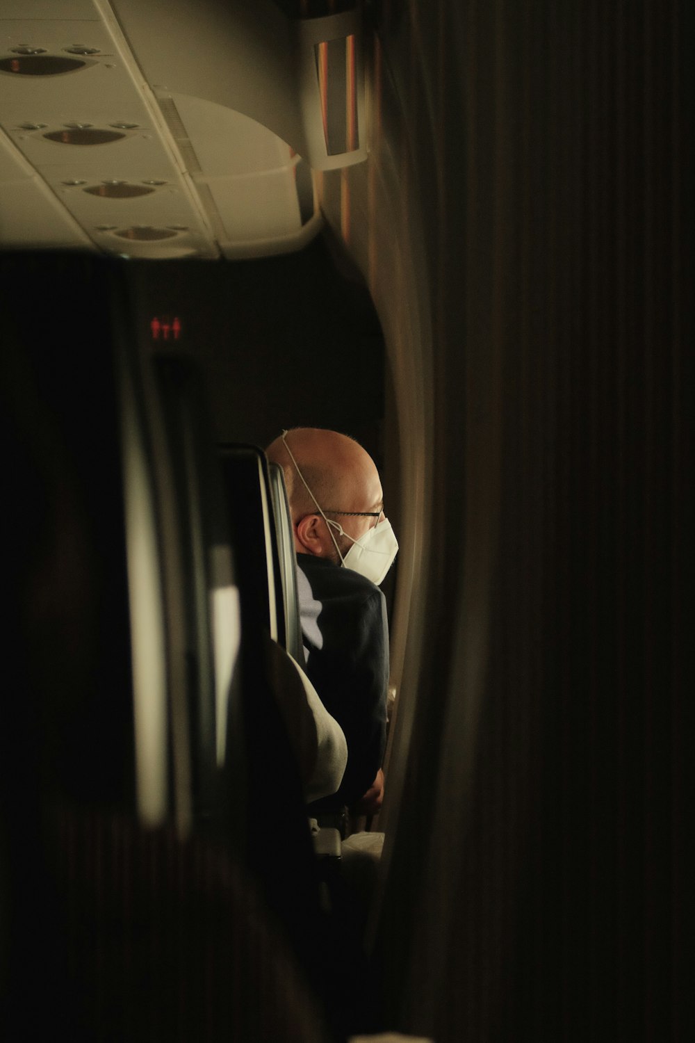 a man in a suit looking out a window