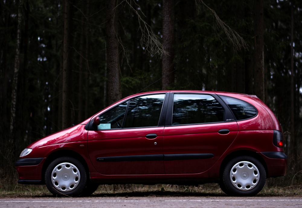 a red car parked in a wooded area